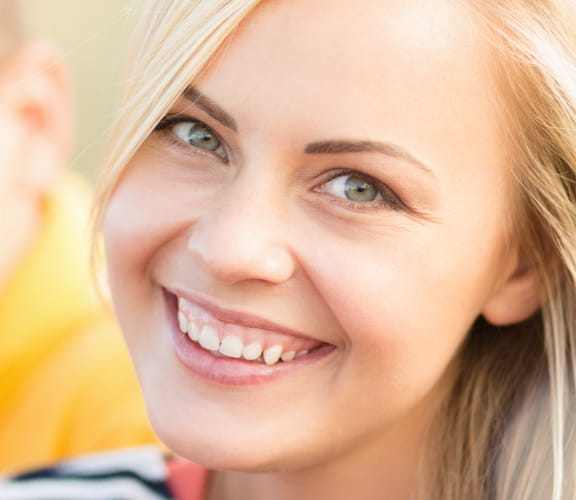 Young woman sitting next to a young man and smiling